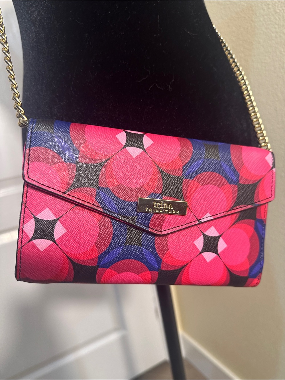 Trina Turk pink, red, black and blue cross body clutch with gold tone chain